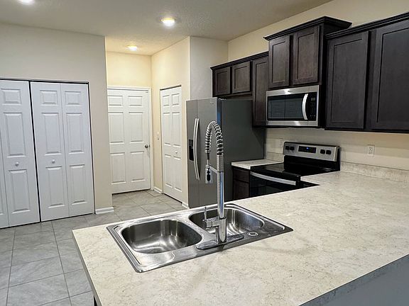 View of the kitchen/garage entryway. Washer/dryer behind the closet doors on the left. Pantry closet on the right.