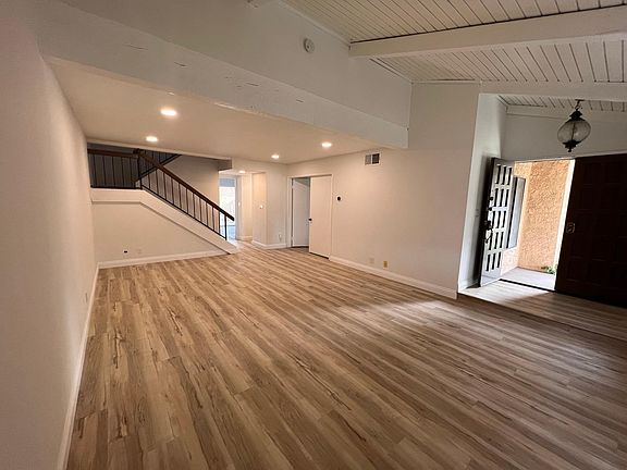 Entry way with living room and dining room and a den with closing door .