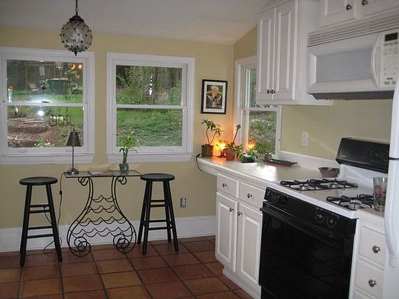 Kitchen with mexican tile floors, windows with view of backyard
