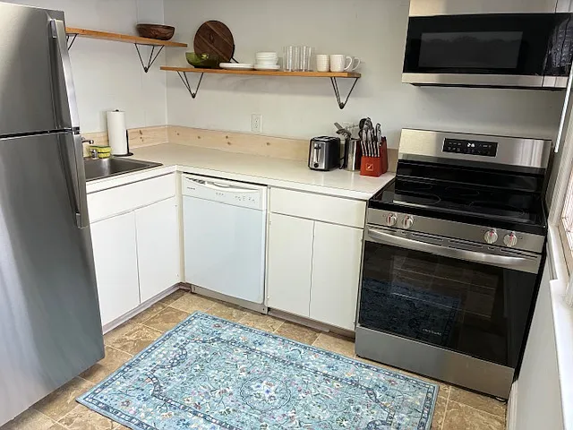 Kitchen with newly installed fridge/freezer, stove, and microwave