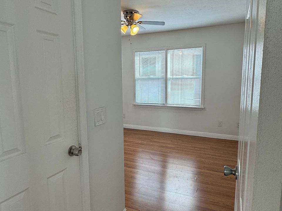 View of the utility closet and bedroom with ceiling fan.