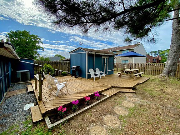 Back deck, picnic table, umbrella, and storage shed, gas grill, fire pit (not pictured)