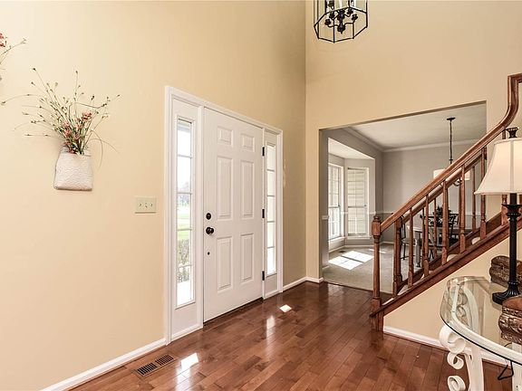 Warm & inviting 2 story entry features wood floors and oil rubbed bronze light fixtures.