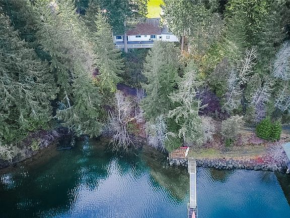 Aerial view of the detached ADU, boat house, expansive dock and waterfront. 