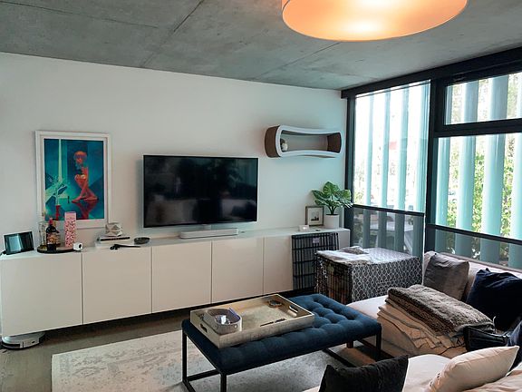 Living room with built-in cabinets, mounted TV and luxurious 9-ft interior define custom sectional.