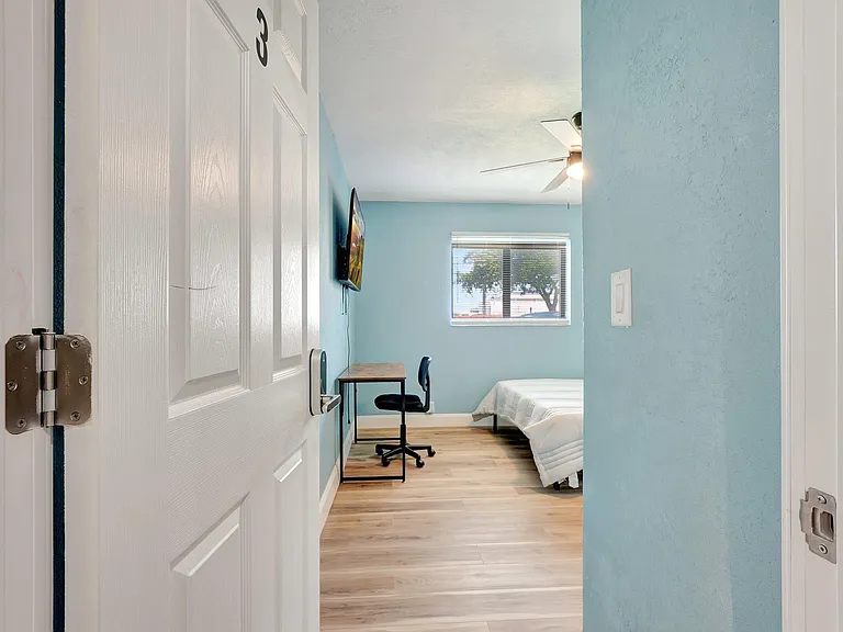 Bedroom with desk, tv and closet