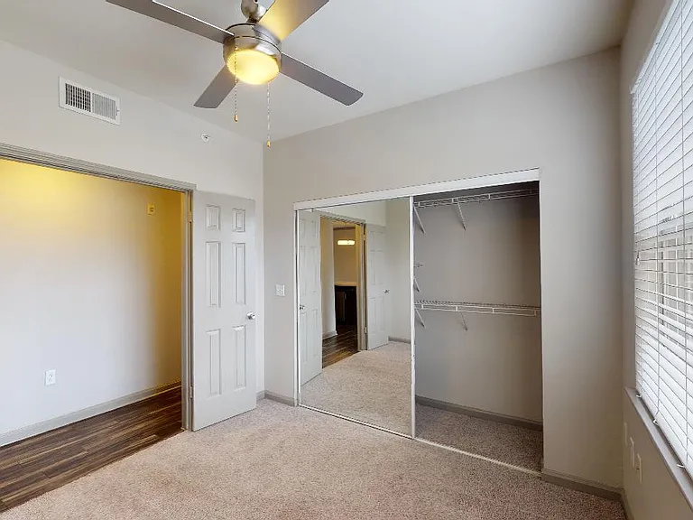 Spacious apartment bedroom with plush carpet flooring