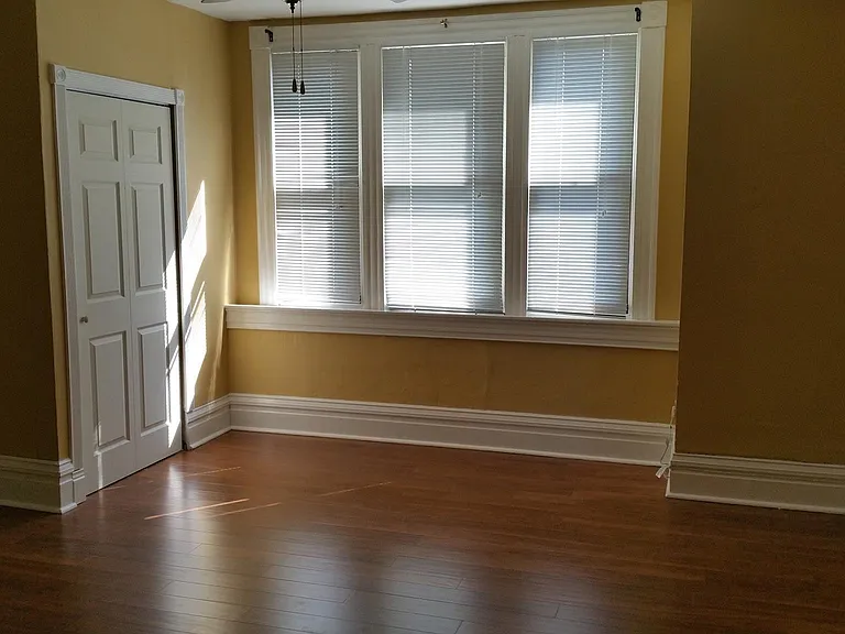 The front - "master" bedroom is the larger of the two bedrooms. It features beautiful windows, a large closet, a small closet, wood floors, and a ceiling fan. It overlooks the quiet street out front; and has good storm windows on it.