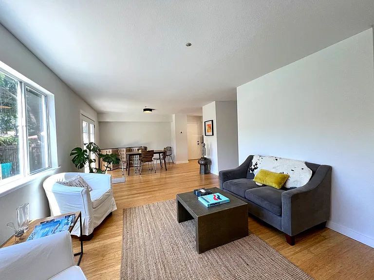 Open floor plan with living room and dining room looking out to backyard