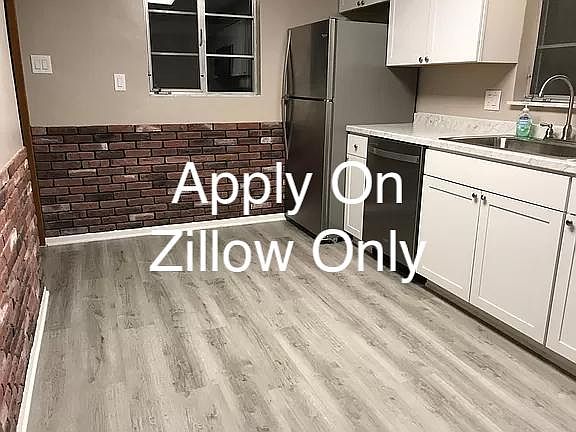 New Kitchen with shaker cabinets, stainless appliances including refrigerator, microwave, oven and dishwasher. New laminate floors, brick chair rail.