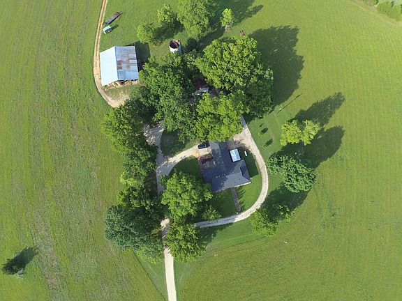 Home rests within the scenic circular drive amid numerous Oak and Pecan trees