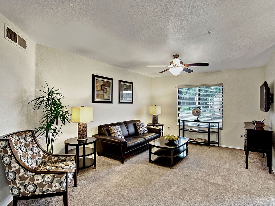A living room with a ceiling fan and sliding glass doors