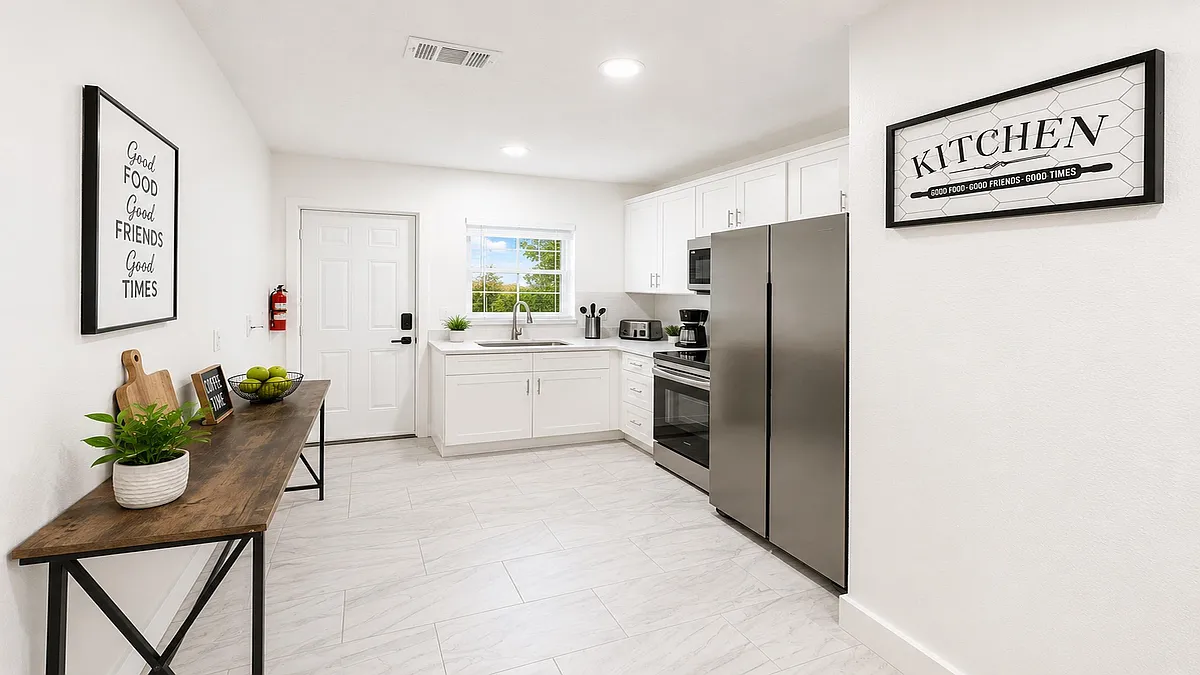 Efficient kitchen with white cabinetry, stainless steel appliances, and a window over the sink plus space for a small table. - Rosegay Ct