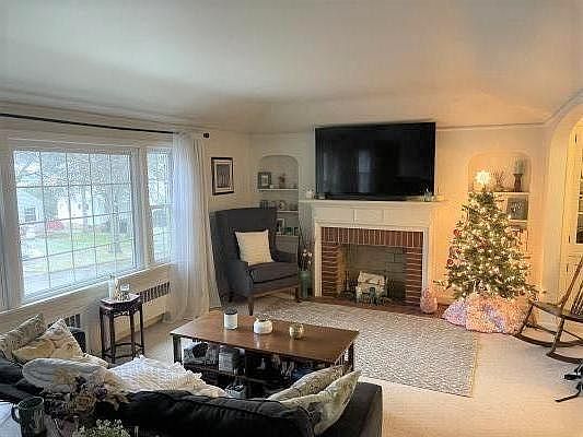 Just a portion of the living room with Faux fireplace. Curtain rods furnished for your use. Lots of windows bring light into the space.