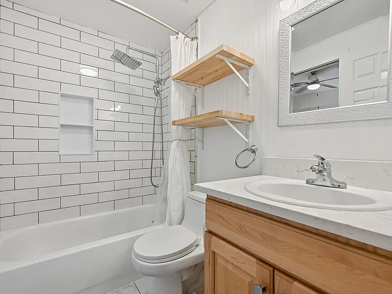 Newly remodeled secondary bathroom with bathtub. Dual rainfall and second detachable shower head. Also with quartz countertops.