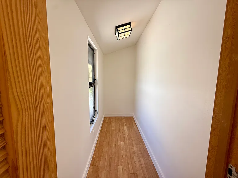 Additional enclosed flex space off the bedroom, featuring a window with natural light.