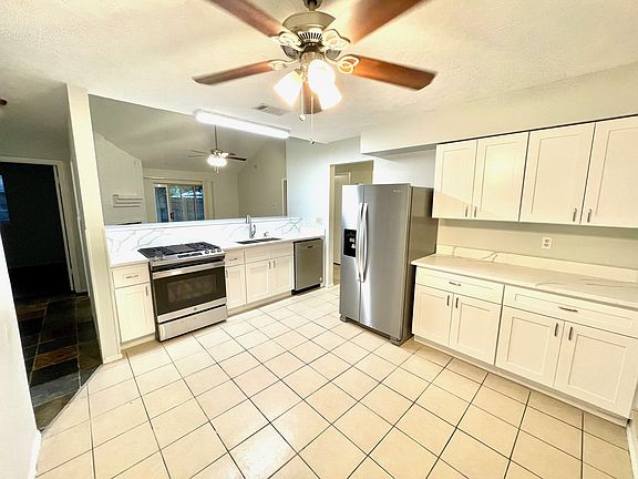 Modern kitchen features quartz countertops and stainless-steel appliances.