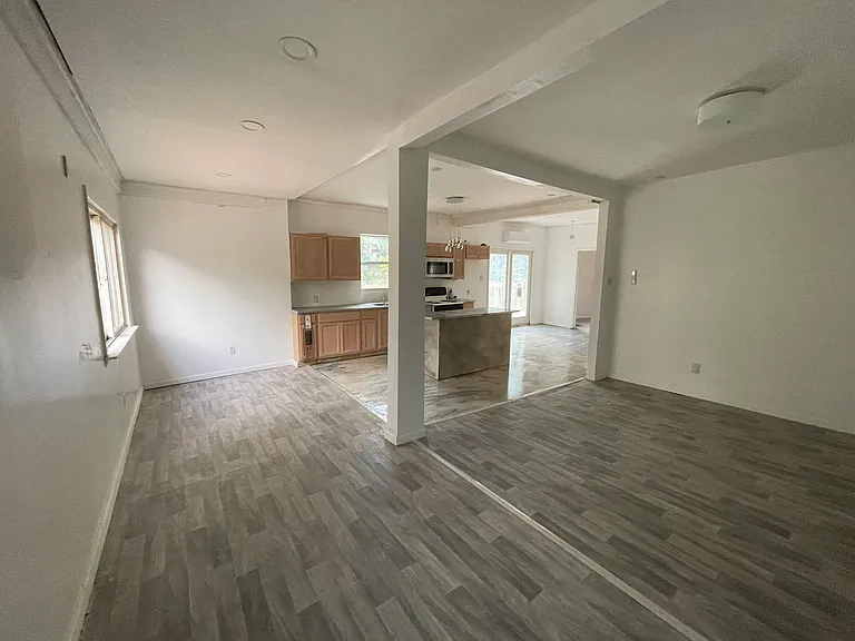 Open concept view of living room & kitchen & you can see patio door where you can step out onto beautiful deck