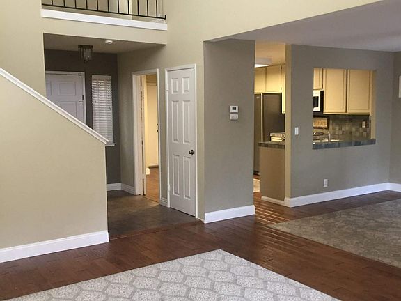 the living room has a vaulted ceiling with the dining room on your right