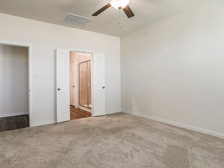 Unfurnished bedroom with ceiling fan and carpet floors