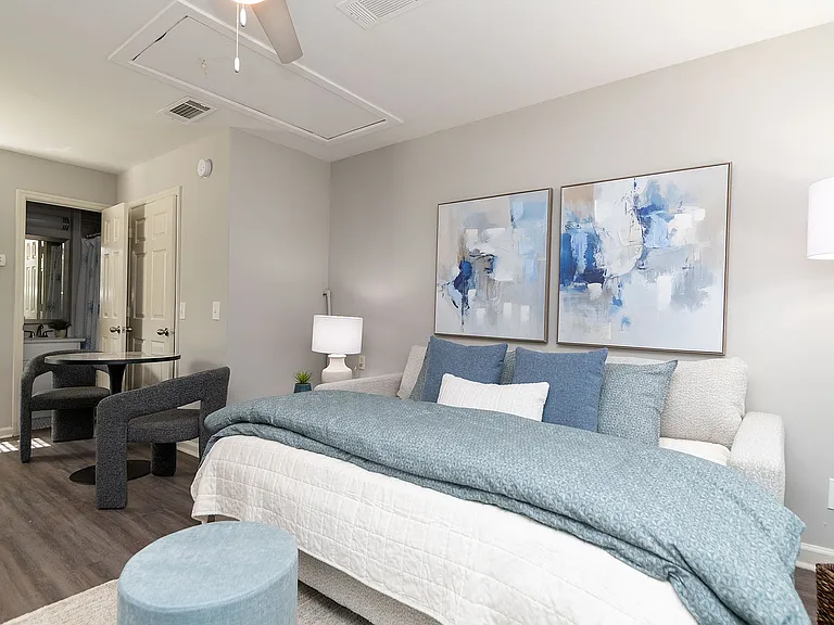 Spacious open living & sleeping area with hardwood-style flooring & ceiling fan