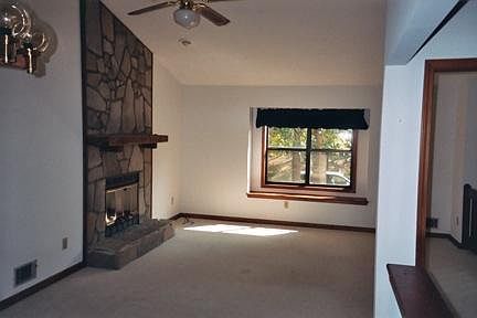 Living room with stone fireplace and high ceilings