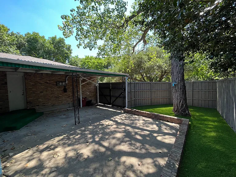 Fenced backyard with covered area, pet turf, and privacy fence
