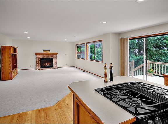 Family room off kitchen features gas woodburning fireplace, eating area 