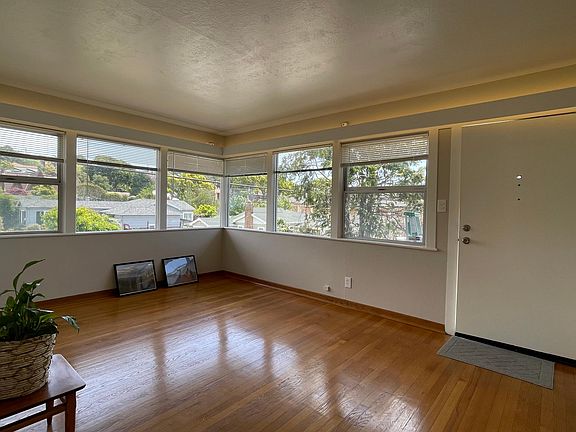 Spacious and light-filled living room with beautiful natural hardwood floors. See the accent lights recessed at the top. it's a welcome to come home to this relaxing space.
