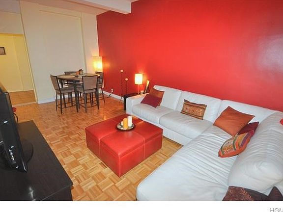 Large living room has 9'- 6" beamed ceilings, refinished parquet floors and is large enough for both a living area and dining area.