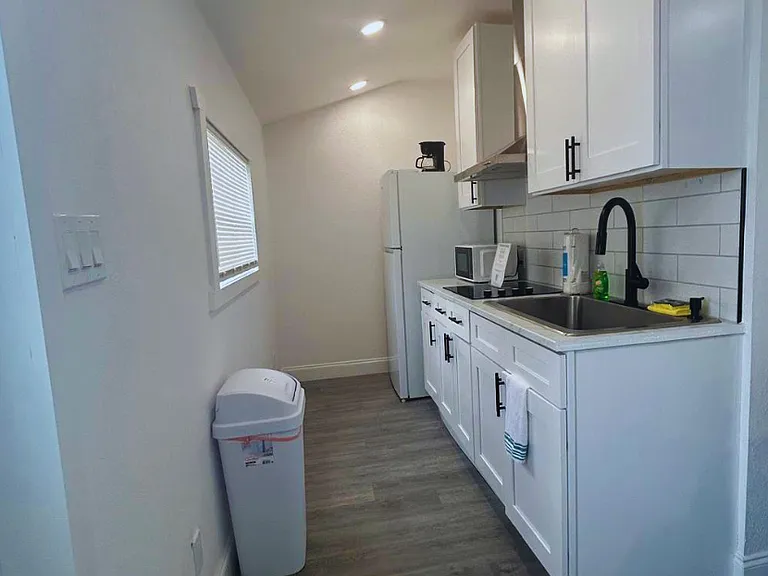 Cozy kitchen equipped with fridge and essential amenities.