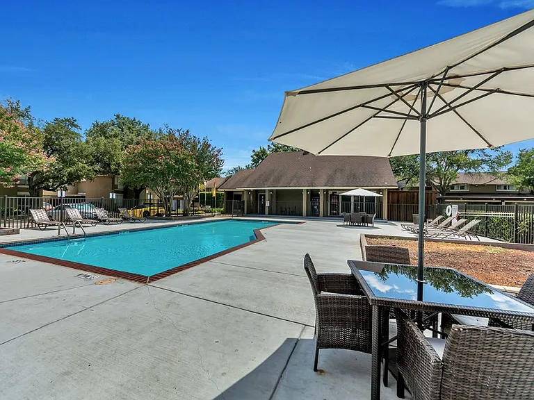 Resort-style swimming pool with sun deck at Watersong Villas Apartments in North Dallas