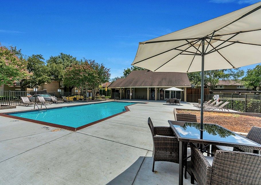 Resort-style swimming pool with sun deck at Watersong Villas Apartments in North Dallas