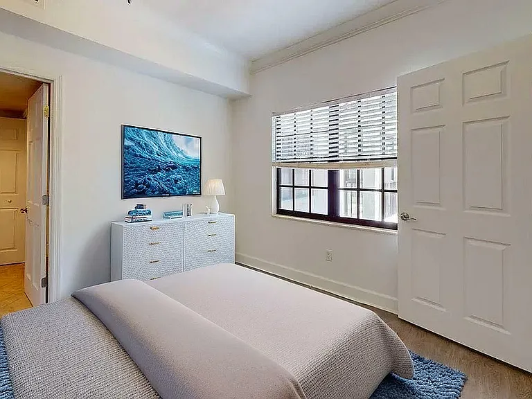 Bright and cozy bedroom with modern decor, featuring a comfortable bed, stylish dresser, and large window for natural light.