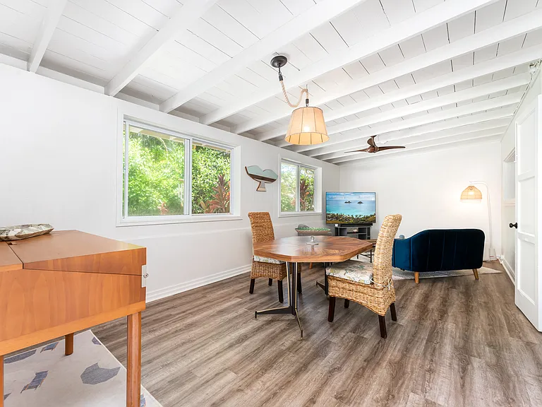 Bright entry room in the main home featuring open beam ceilings, luxury vinyl flooring, and abundant natural light.