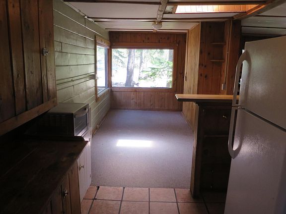 View from kitchen to dining area with large windows and built-in shelves.