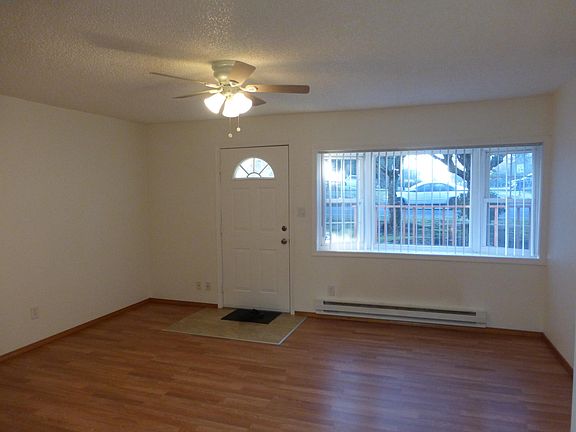 Front living room with bay windows and ceiling fan.