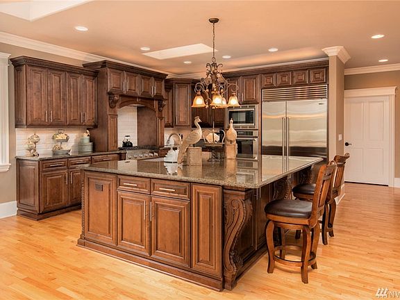 Gourmet kitchen with massive granite island with eating bar.  Solid wood cabinetry, intricate trim detailing. 
