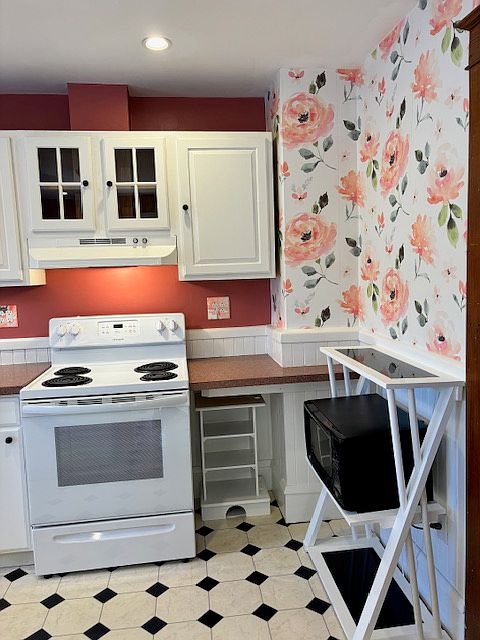More shelves underneath counter and microwave with additional shelving. Glass front doors above oven fan/light