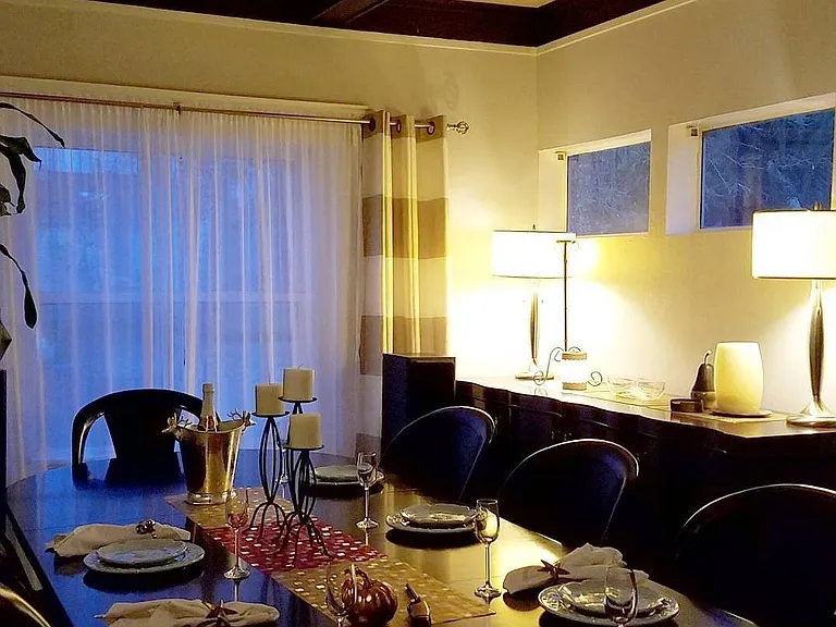 Large room with exposed beams features a wet bar. Can be used as a formal dining room for entertaining or as a great family room for cozy movie nights.
