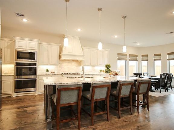 Gorgeous Chef's Kitchen. Double ovens, gas cooktop, modern tones, and an oversized island opening to the living and breakfast room.