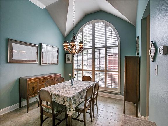 This spacious formal dining room can accommodate any sized furniture and features a lovely ceiling, chandelier and arched floor-to-ceiling window with plantation shutters.