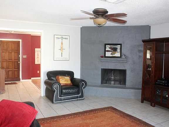 Corner fireplace in the den.  This angle shows you the view looking from the den towards the entry.  You can see the beautiful ceramic tile floor in the entry and flowing thru the den.