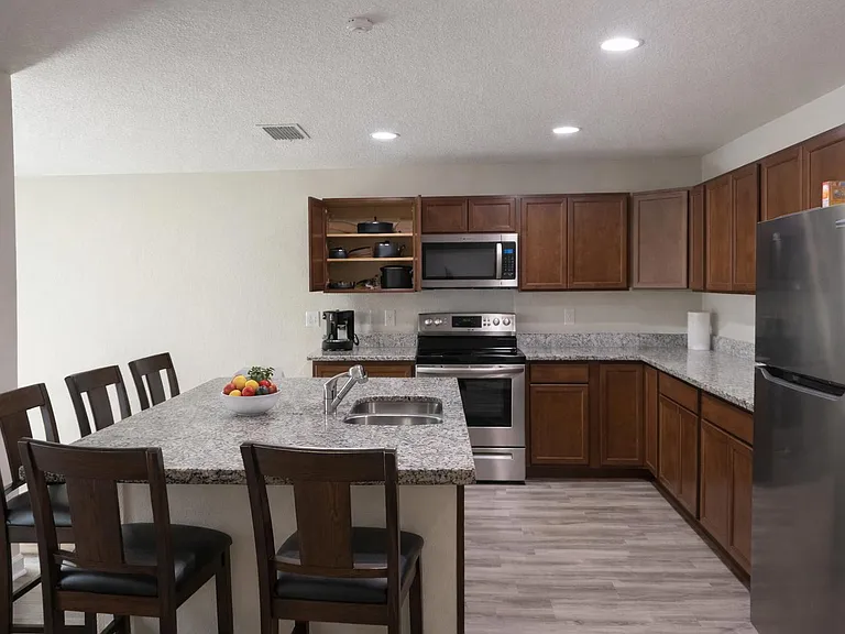 Spacious U-shaped kitchen with granite-look counters, breakfast bar seating, and stainless steel appliances.