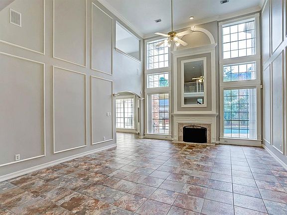 Spacious Living room with gas fireplace and large windows looking out to the pool