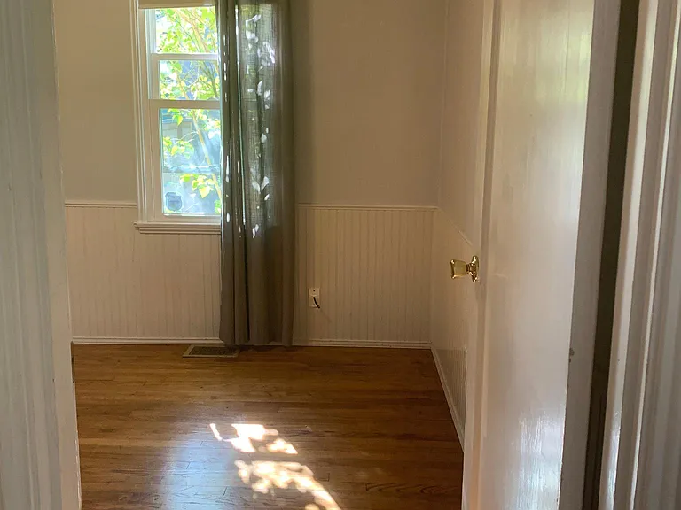 Both bedrooms have hardwood floors and a lilac tree outside the windows