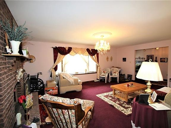 Lovely Living Room just off Front Entry w/ Gorgeous Crystal Chandelier, Big Front Bay Window & Brick FireplaceSpacious Rooms, plenty of Natural Light & Wide Openings thru-out!!!