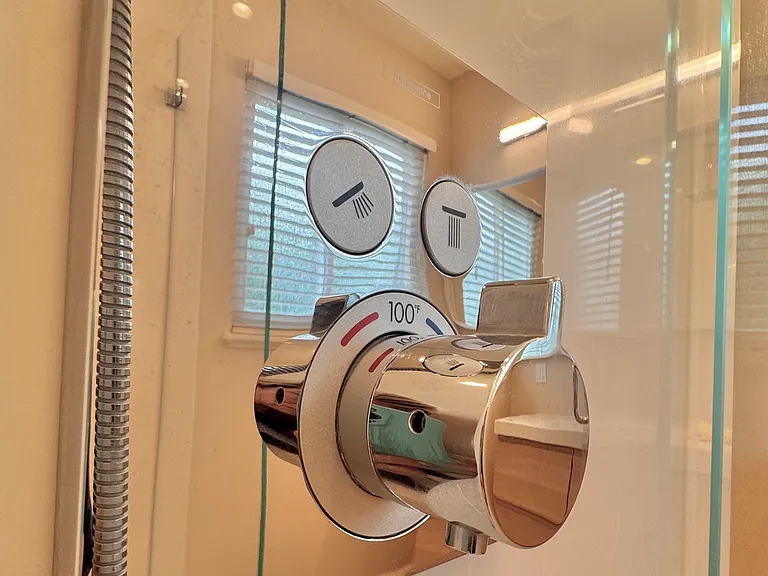 ...with stylish pushbutton Grohe rain shower overhead and flexible wand.