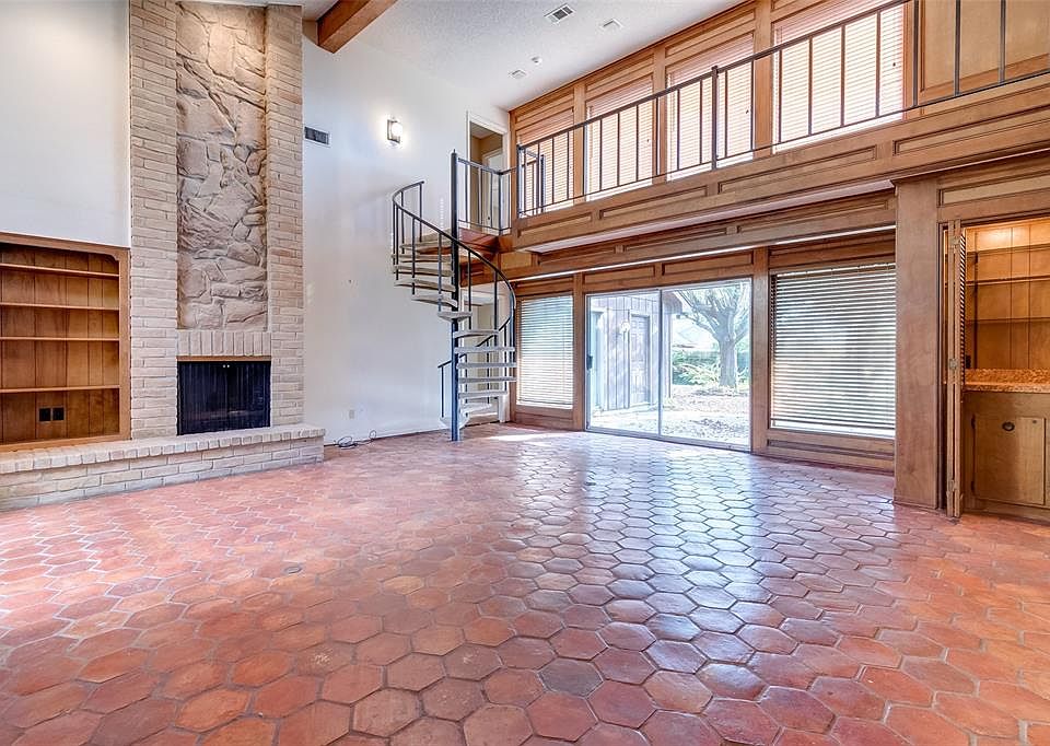 What a great room! Beautiful honey comb terra-cotta tile, brick and stone gas fire place, wood beams and paneling all in this light and open living room.
