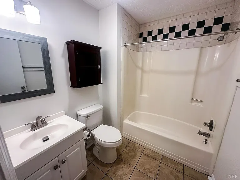 a full sized bathroom tastefully updated with a spacious vanity with ample storage, a well lit mirror and a full tub/shower combination providing both convenience and comfort